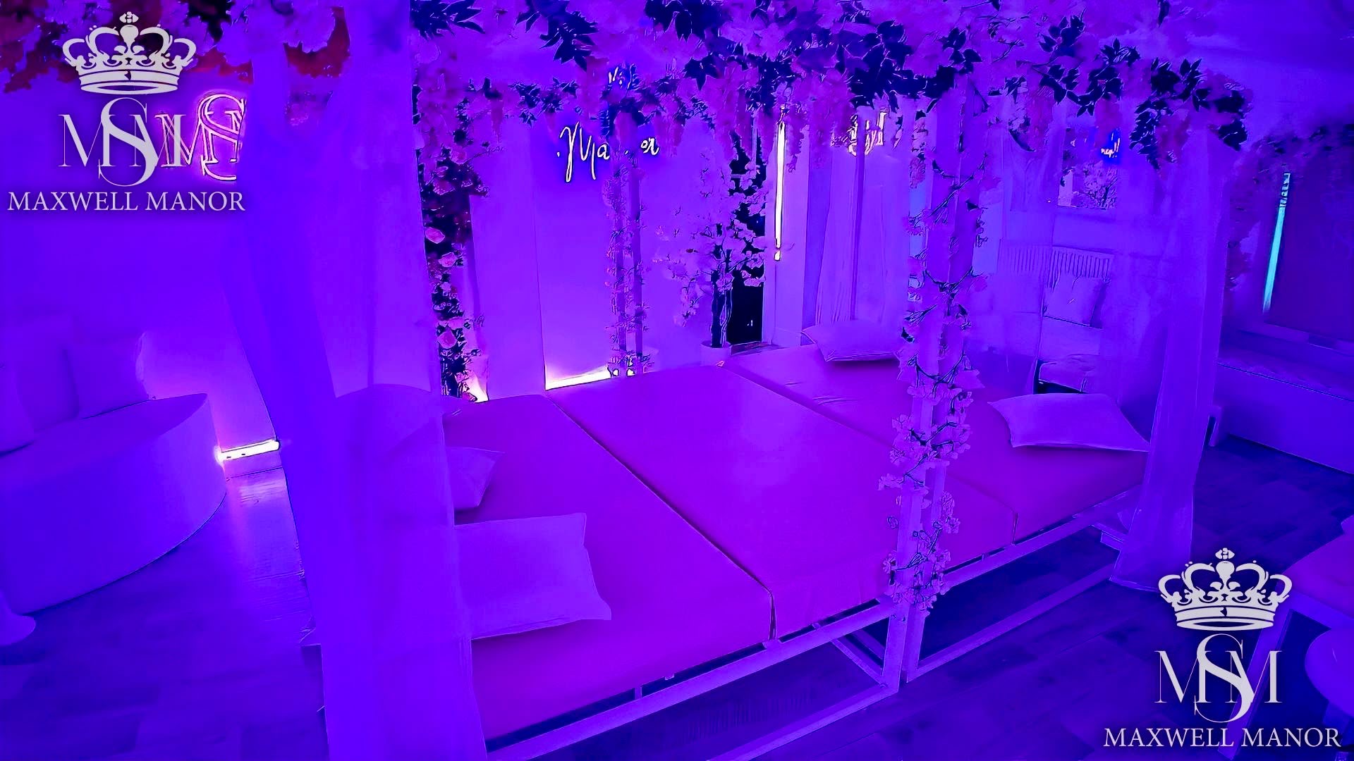 The same room washed violet, with draped voile and blossom around the bed